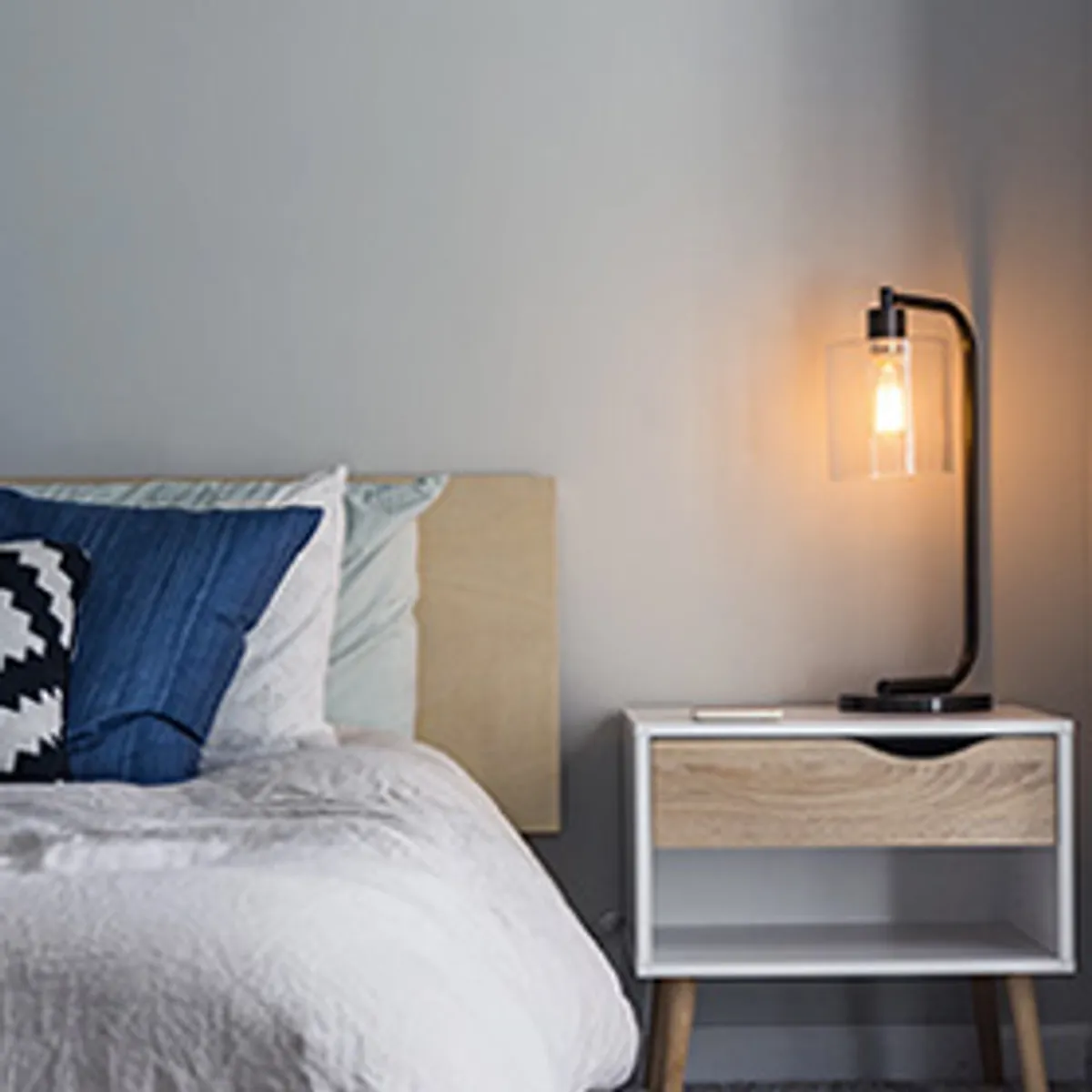 A blue bedroom with a woven pendant lamp